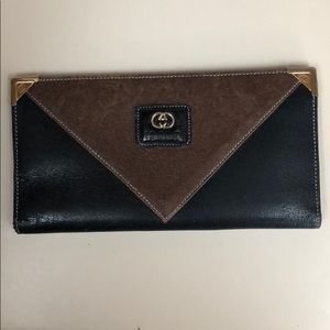 Gucci wallet black and brown with gold insignia.